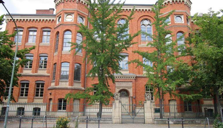 Rotes Gebäude mit Bäumen davor